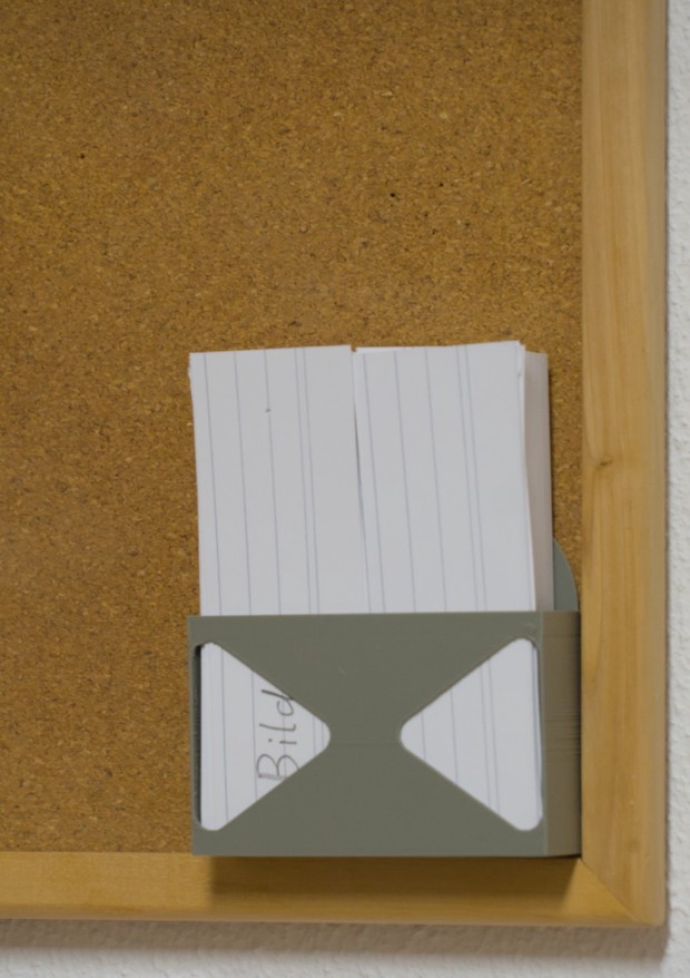 Ein 3D gedruckter Halter mit Karteikarten an einer Pinnwand